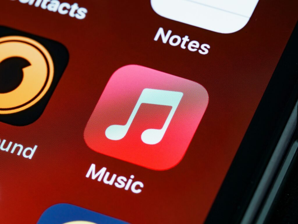 Detailed close-up of an iPhone home screen featuring the music app icon.